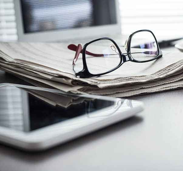 Glasses on Documents next to Tablet